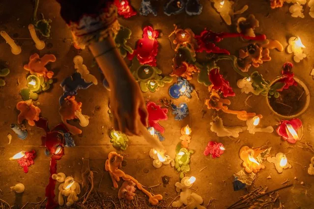 Kashmiri girl lights candles on graves during Shab-e-Barat in Srinagar Kashmir