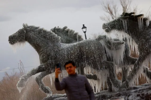Man takes selfie at Los Indomables monument with frozen water during cold snap in Ciudad Juarez Mexico