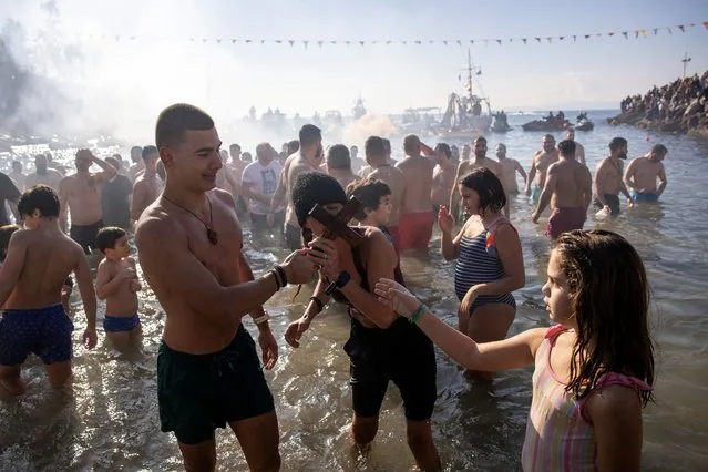 Orthodox faithful kisses wooden crucifix during Epiphany celebrations in Piraeus Greece 2025