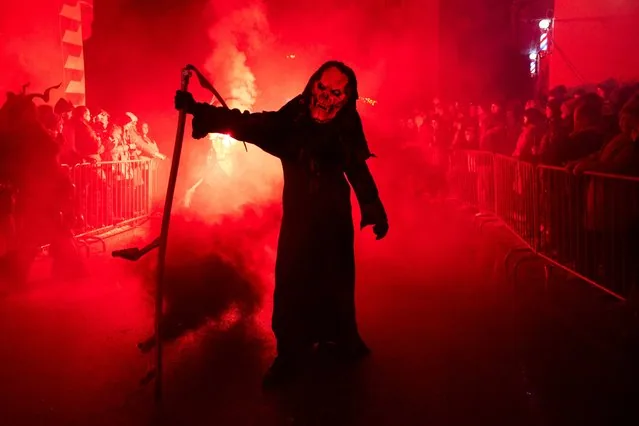 Masked and costumed figure takes part in Perchten traditional parade in Windischgarsten Austria