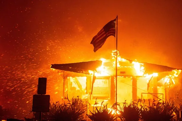 US flag stands as Palisades Fire engulfs structure in west Los Angeles January 2025