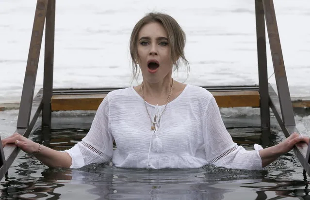 Woman dips in ice hole celebrating Orthodox Epiphany near Bishkek Kyrgyzstan January 2025