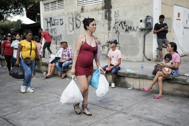 Pregnant displaced woman carrying aid at General Santander Stadium in Cucuta Colombia 2025