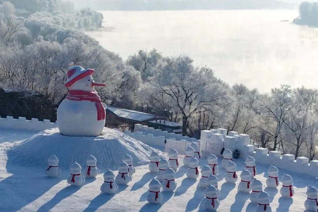 Snowman installations beside frost-covered trees along Songhua River in Jilin China