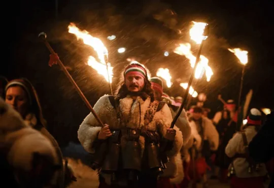Bulgarian kukeri dancers perform Surva ritual with torches bells and masks village Svetlya January 2025