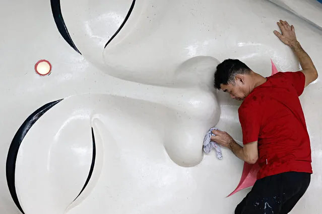 Man cleans sleeping Buddha statue ahead of Lunar New Year at Bogor temple Indonesia January 2025