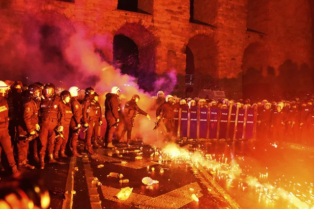 Police officer kicking flare during Istanbul protests against arrest of Mayor Ekrem Imamoglu