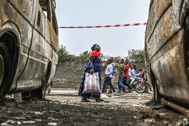 Residents walk past charred vehicles in Goma Democratic Republic of the Congo 2025