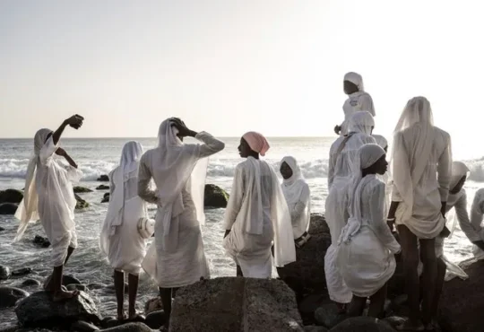 Layene brotherhood followers in white robes gather near sacred grotto in Ngor Senegal