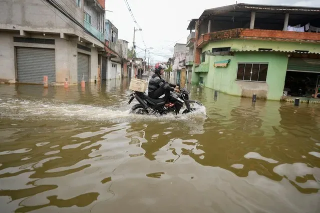 Motorcyclist navigates flooded street in Jardim Pantanal neighborhood Sao Paulo Brazil