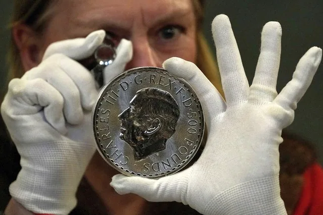 Warden inspects 500 pound coin during Trial of the Pyx ceremony Goldsmiths Hall London