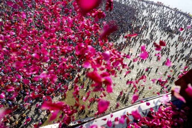 Helicopter showering flower petals on Maha Kumbh pilgrims at Sangam Prayagraj India